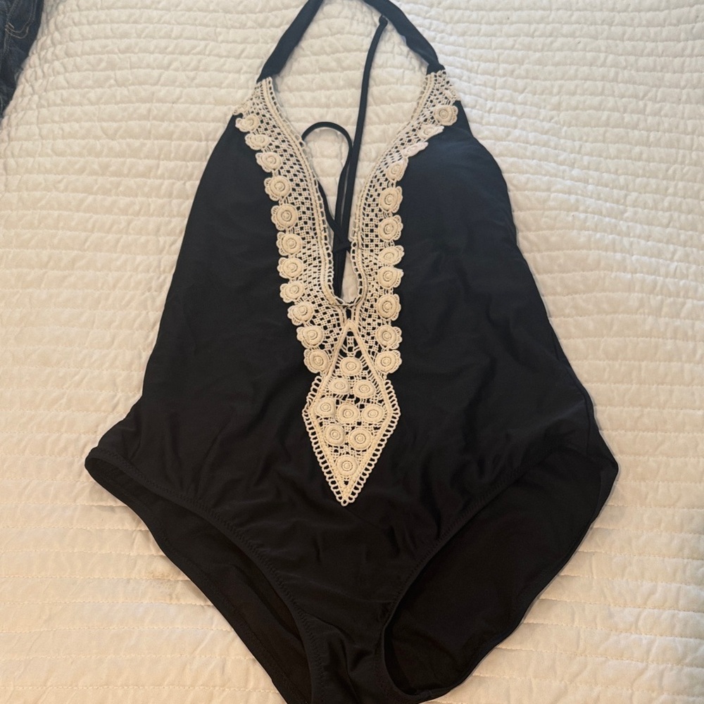 Woman’s one piece with plunging neck line and hand embroidery ties in back